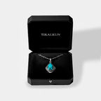 Turquoise pendant necklace in a black Tikalkun jewelry box on a light gray background