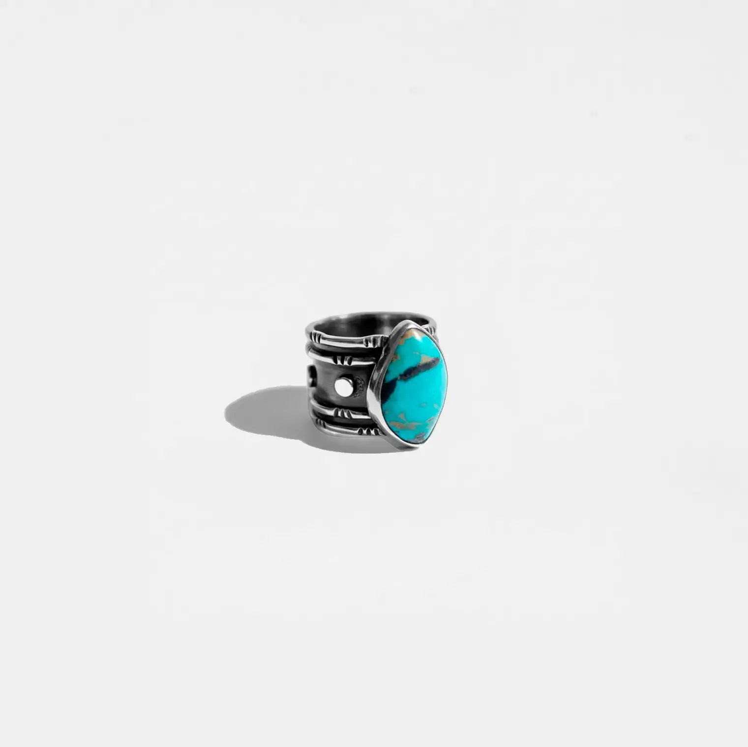 Silver ring with a turquoise stone on a white background