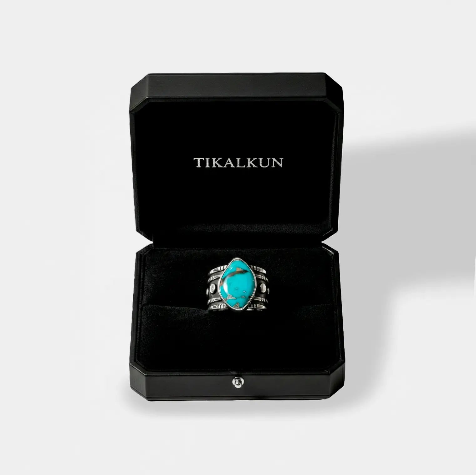 Turquoise ring in a black Tikalkun box on a light gray background