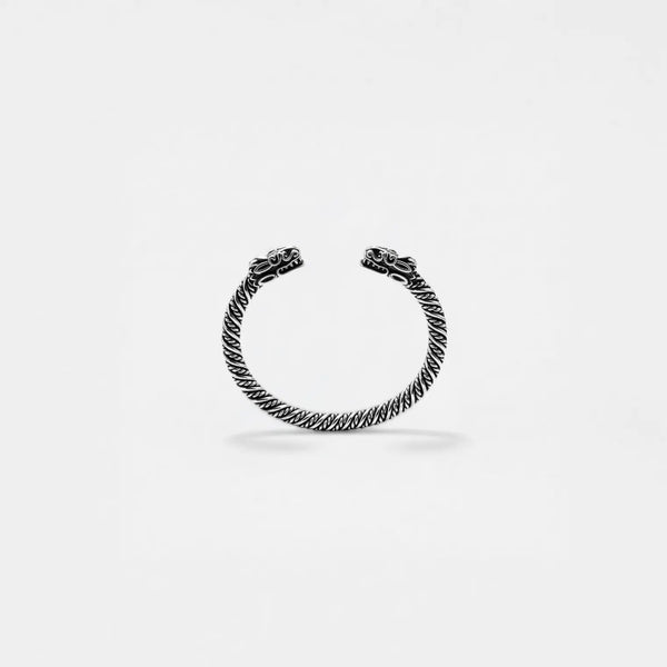 Silver bracelet with quetzalcoatl design on a light gray background
