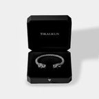 Silver quetzalcoatl bracelet in a black Tikalkun jewelry box on a light gray background