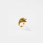 Gold dinosaur-shaped ring on a white background