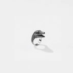 Silver ring with a velociraptor design on a white background