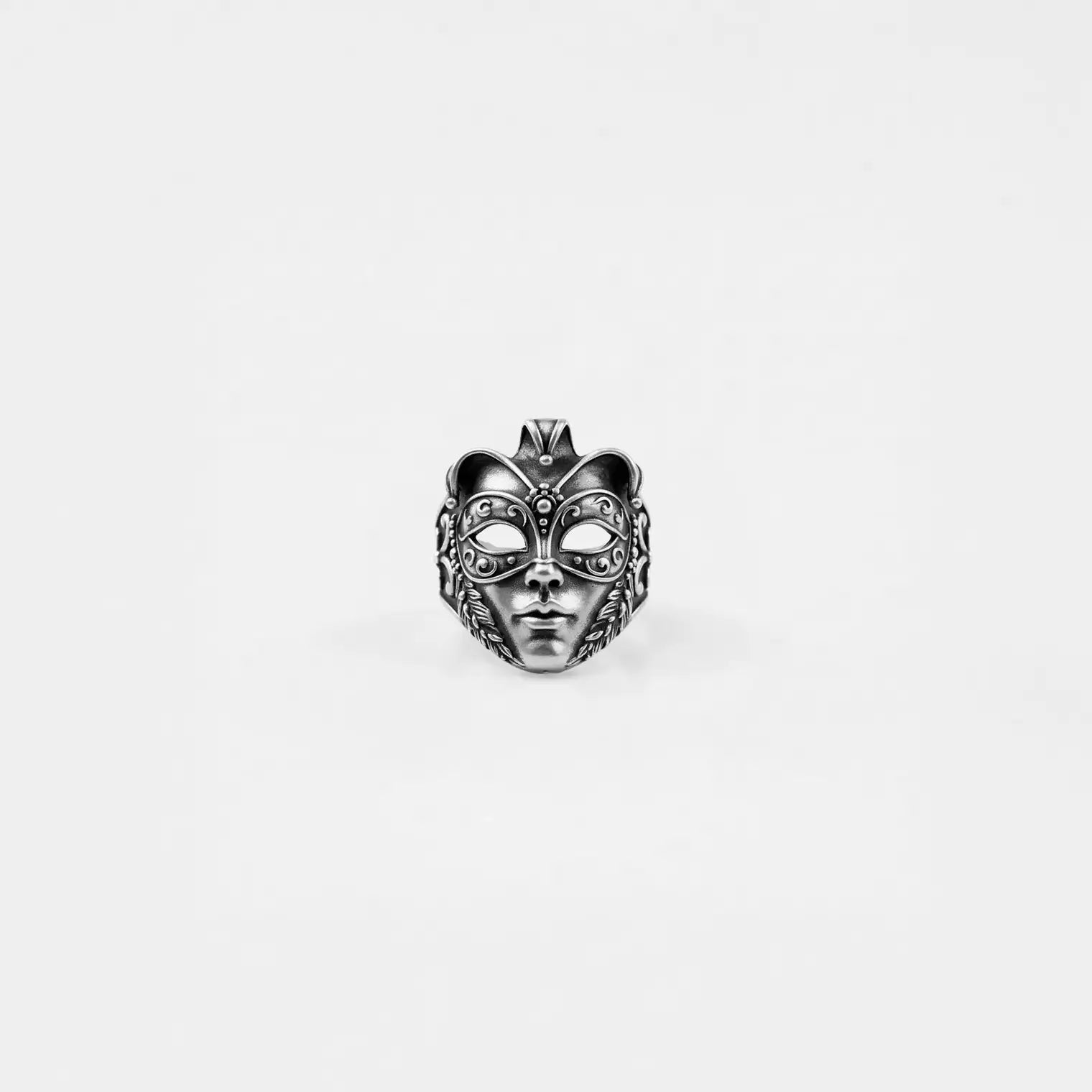 Silver venetian mask ring on a white background