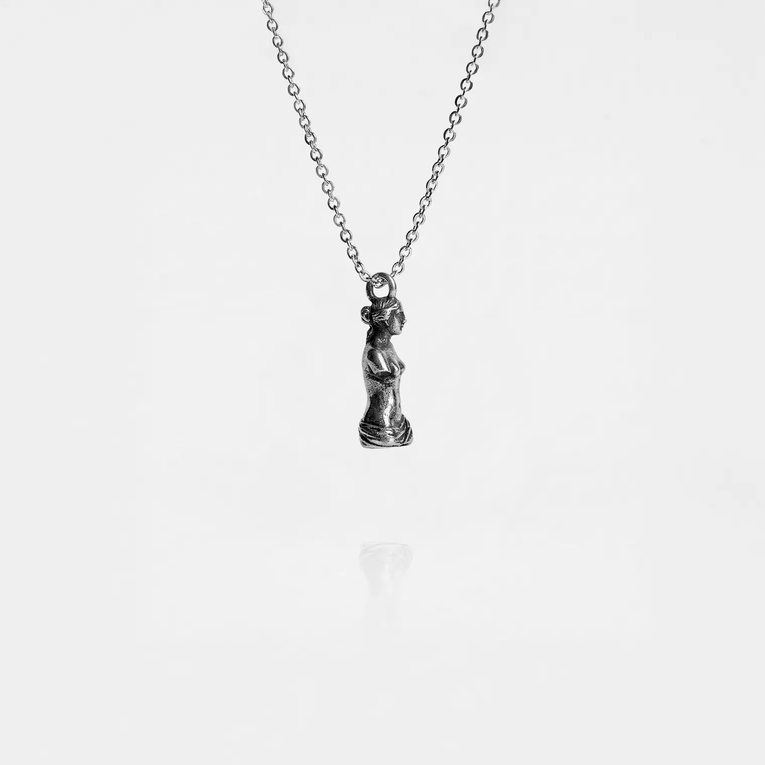 Silver necklace with a venus de milo pendant on a white background