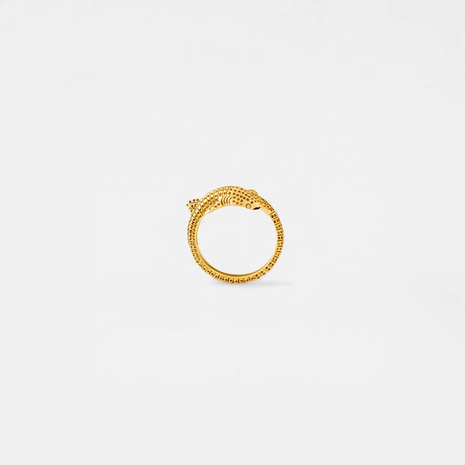Gold whale-shark ring on a light gray background