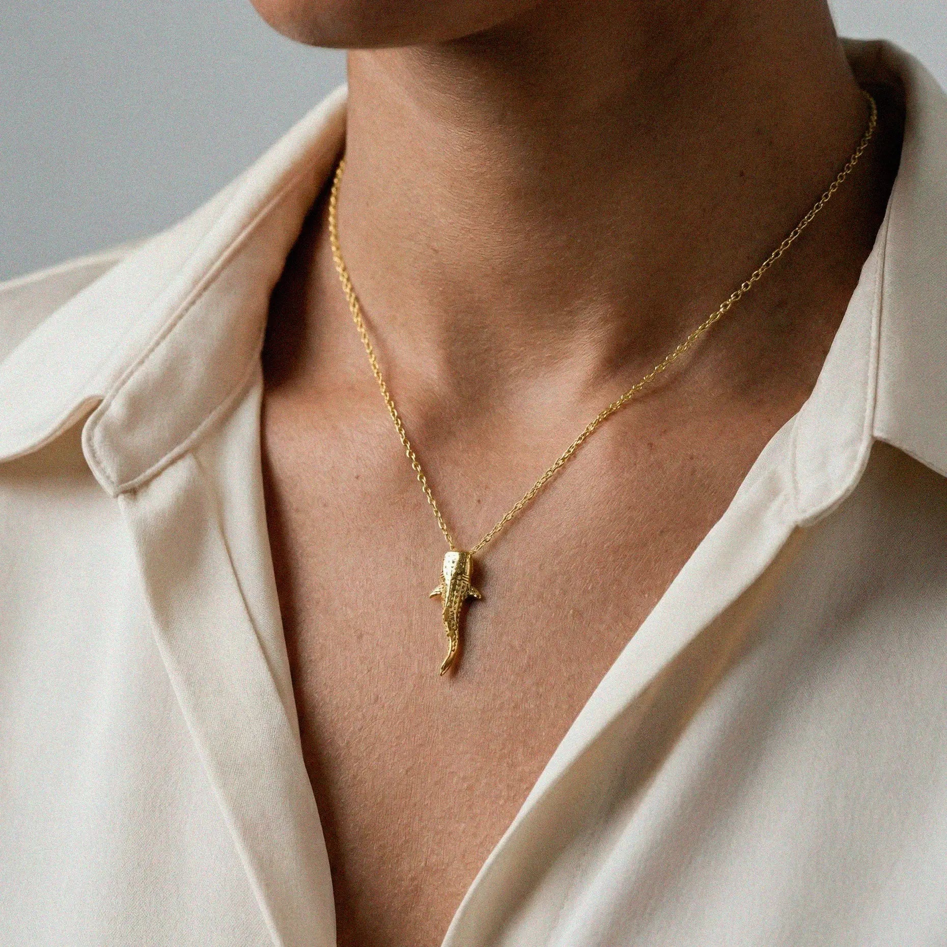woman wearing a Whale-shark gold pendant on a white background