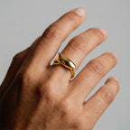 a person's hand wearing white-shark gold ring on a gray background