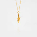 White-shark gold pendant on a white background