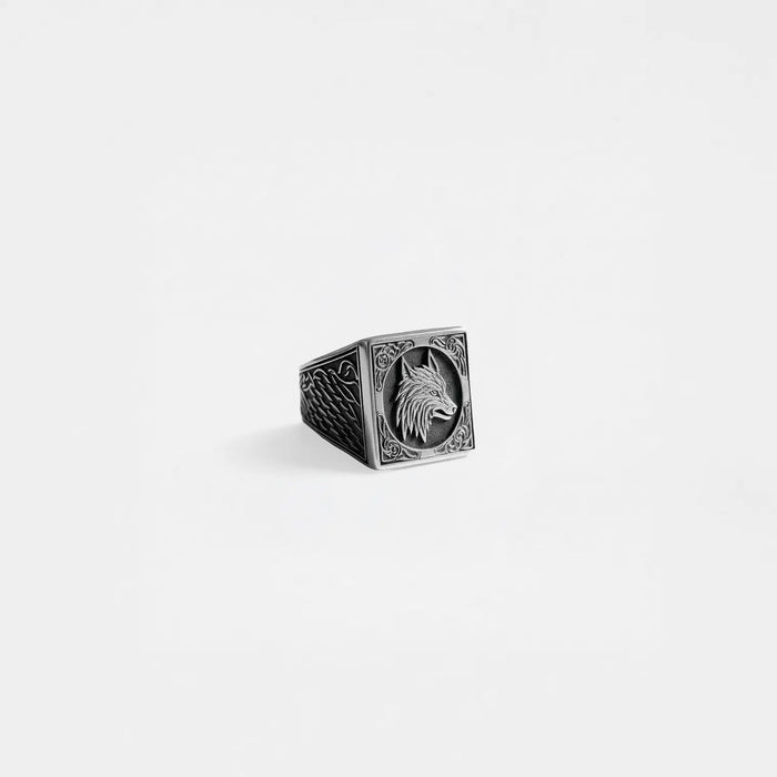 Silver ring with a wolf design on a light gray background