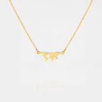 Gold necklace with a world map pendant on a light gray background