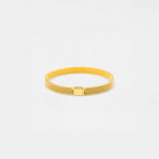 Gold bracelet on a light gray background