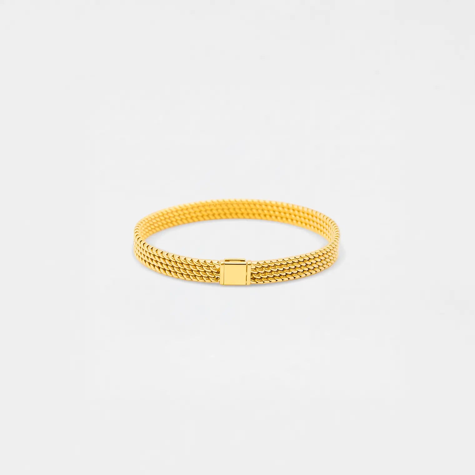 Gold bracelet on a light gray background