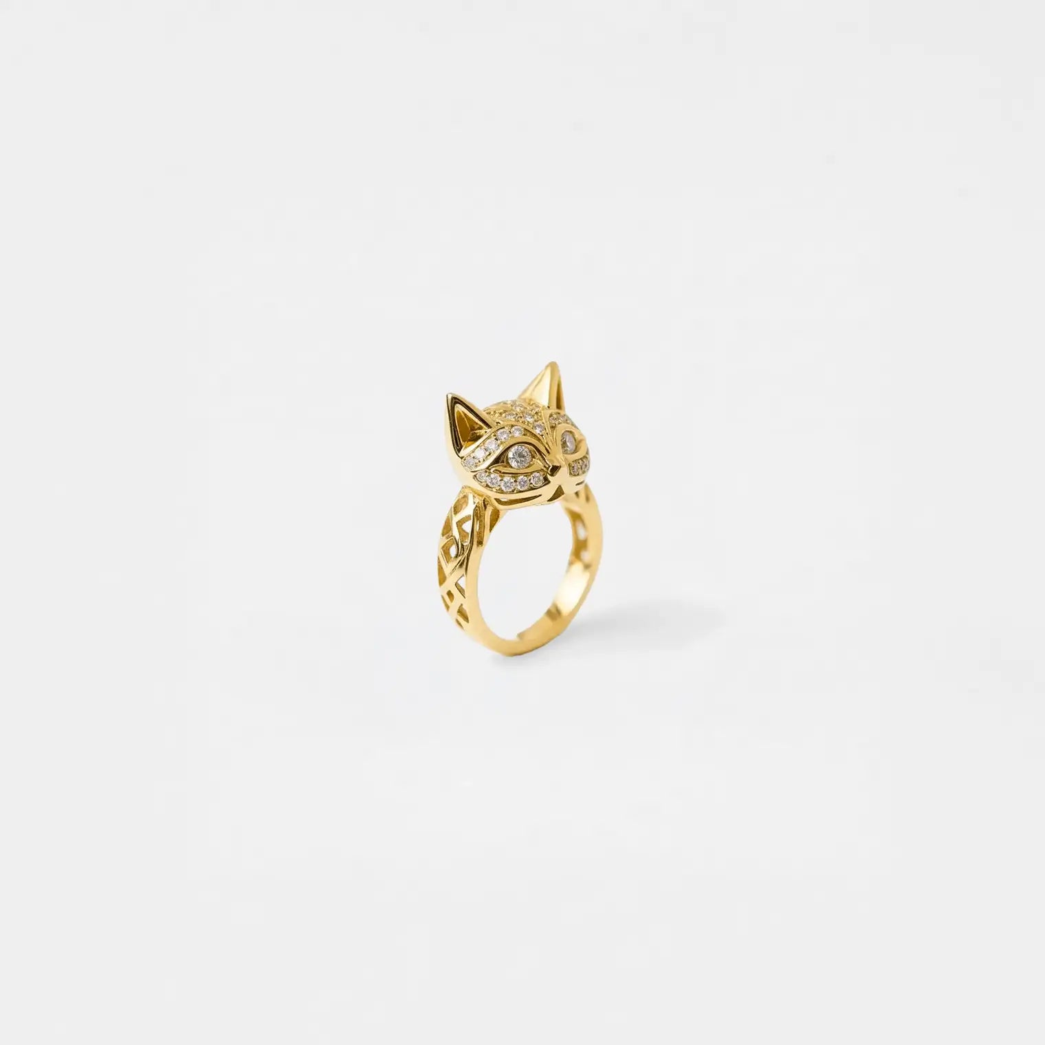 Gold cat ring with sparkling stones on a white background