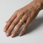 woman's hand wearing a Gold cat ring with sparkling stones on a white background