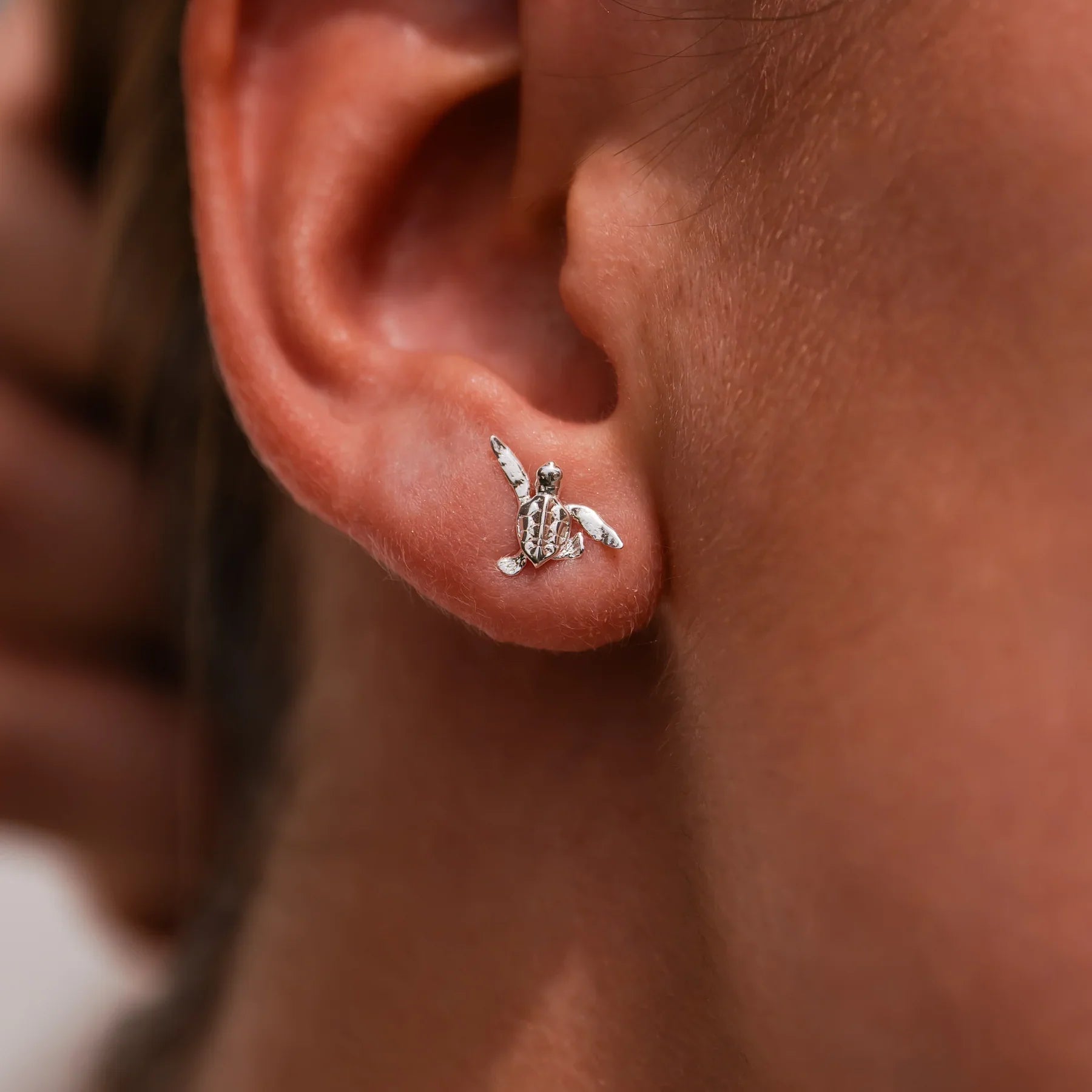 Baby Turtle Earrings – Worn View: A pair of handcrafted earrings in 925 sterling silver, featuring delicate baby turtles inspired by the marine heritage of the Riviera Maya.