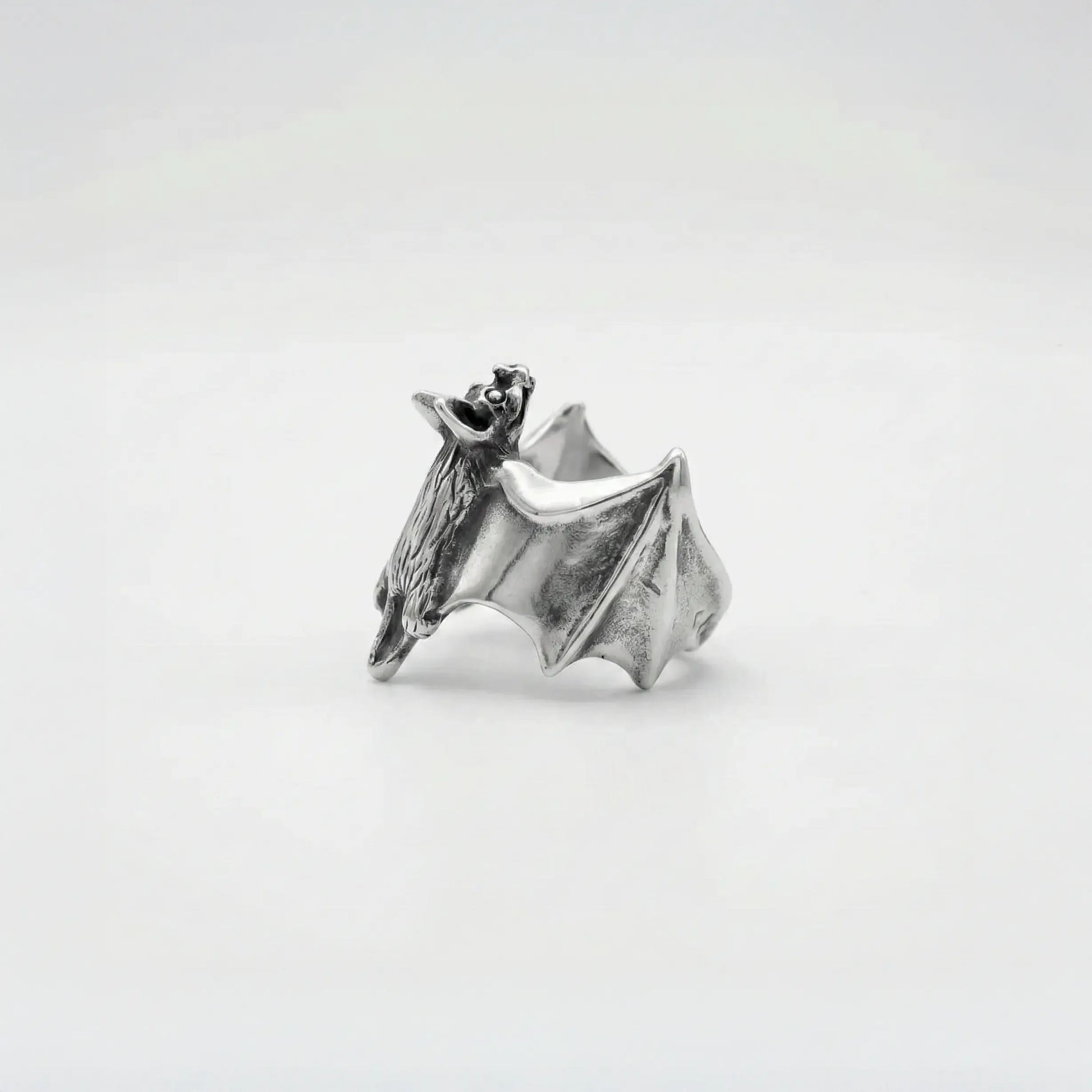 Silver bat-shaped ring on a white background