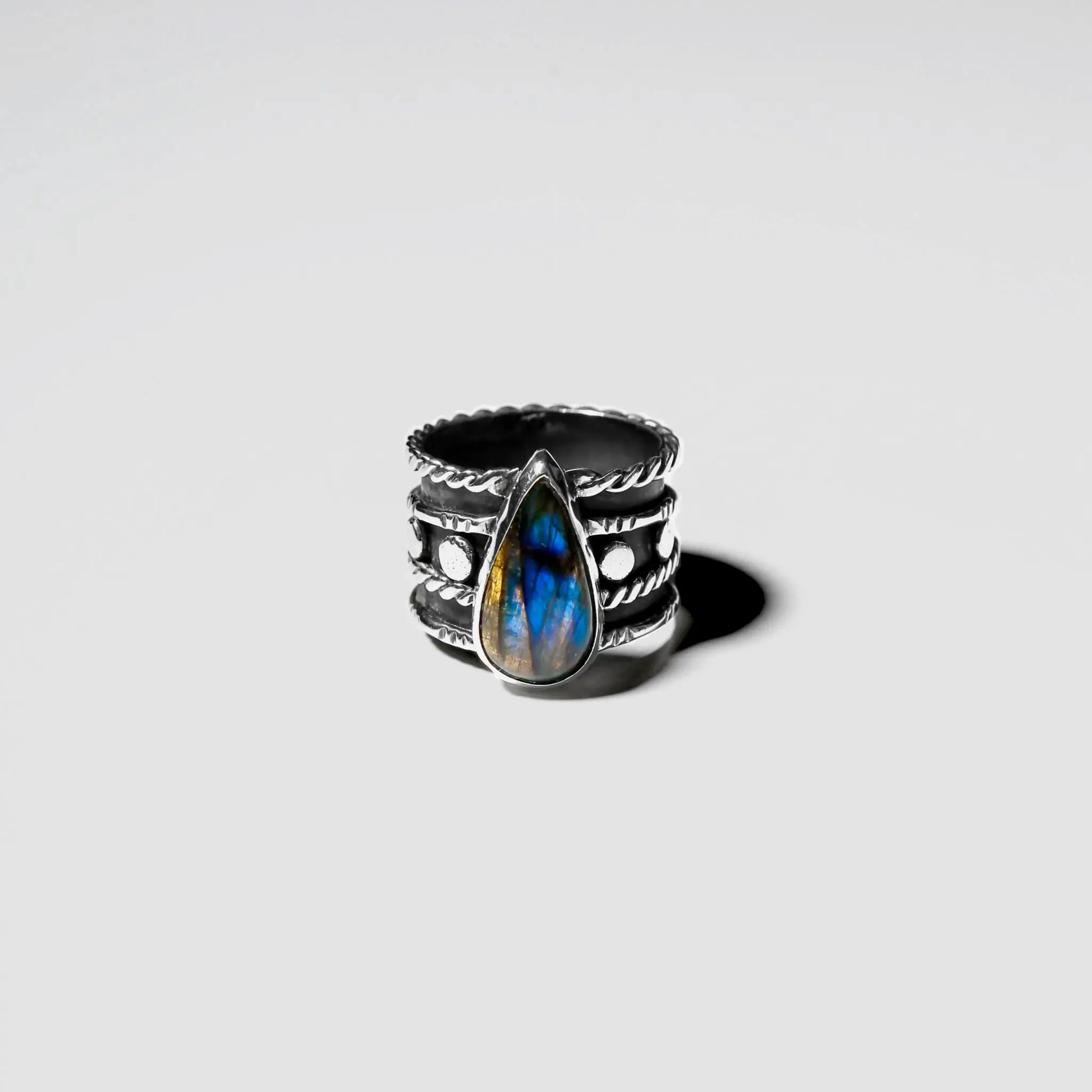 Silver ring with blue stone on a light gray background