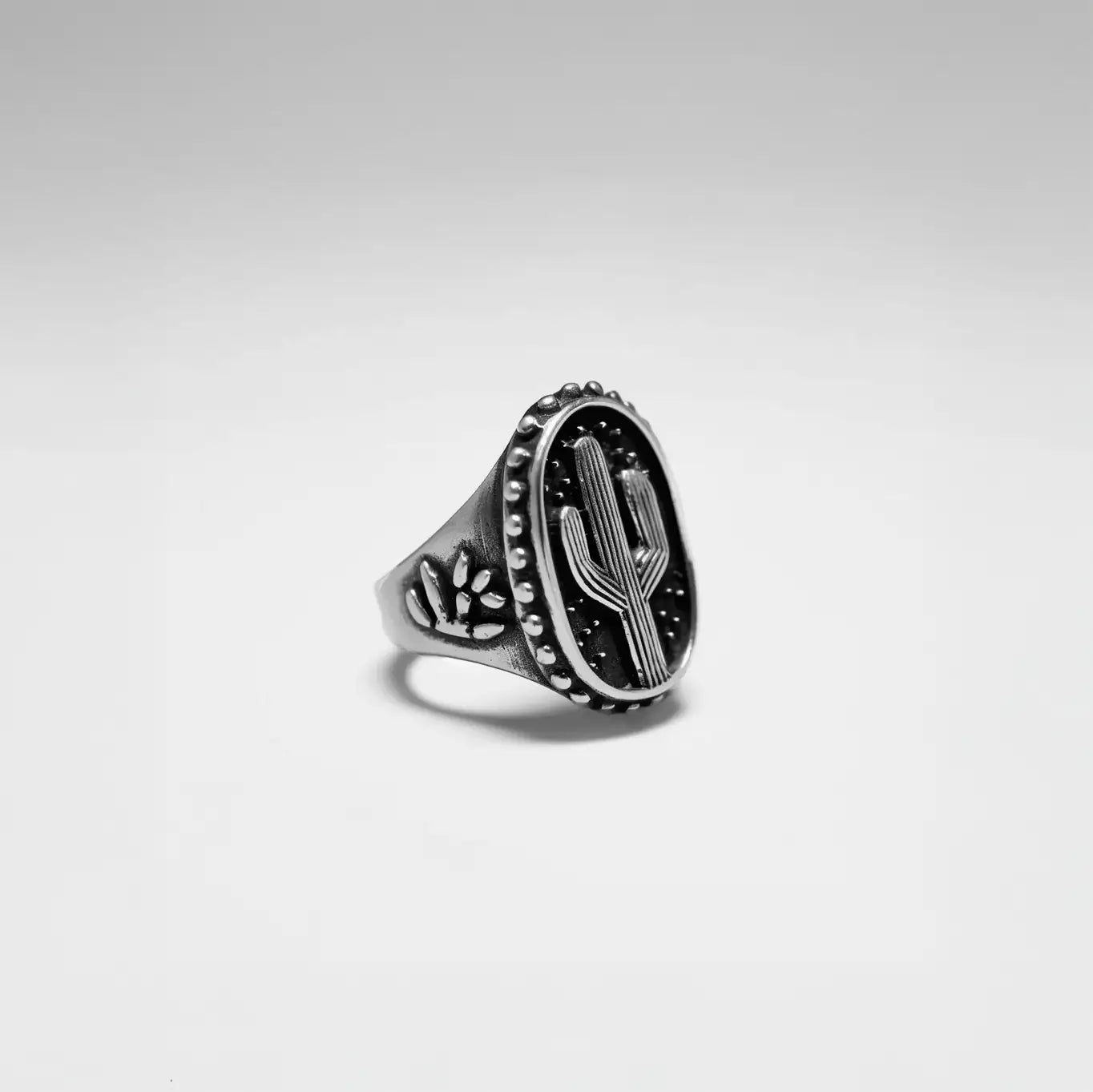 Silver ring with cactus design on a gray background