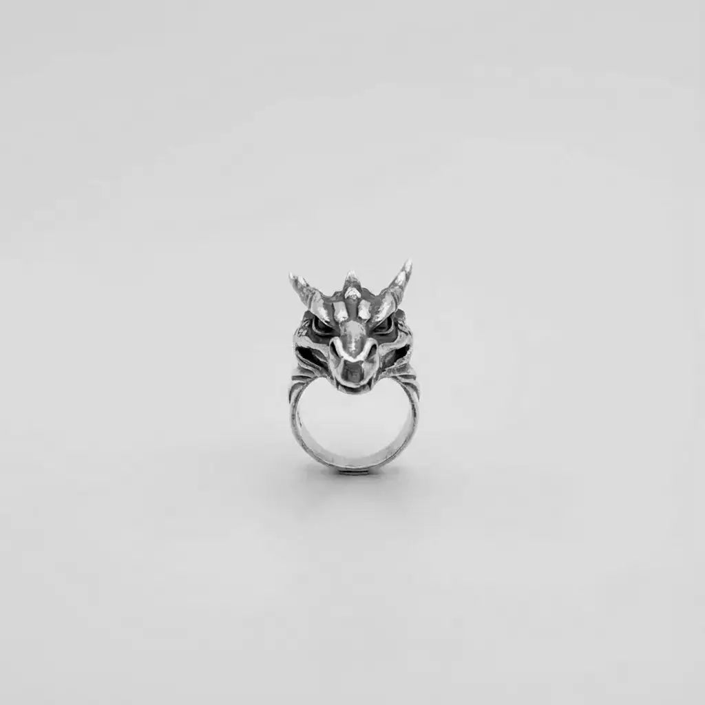 Silver dragon head ring on a white background