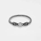 Silver bracelet with quetzalcoatl, the feathered serpent design on a light gray background