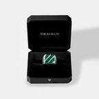 Silver ring with green stone in a black Tikalkun box on a light gray background