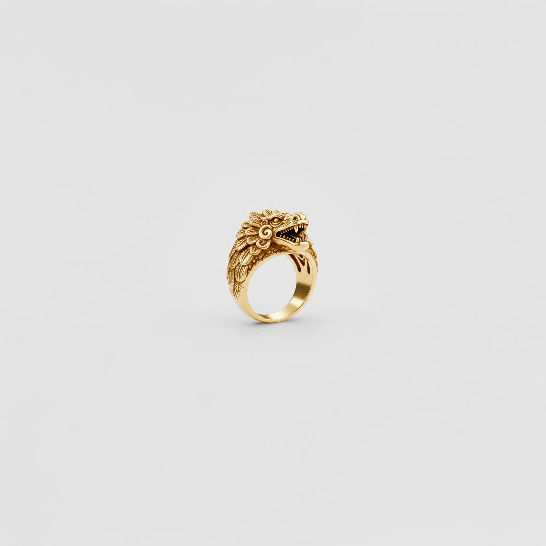 gold ring with kukulkan design on a light gray background