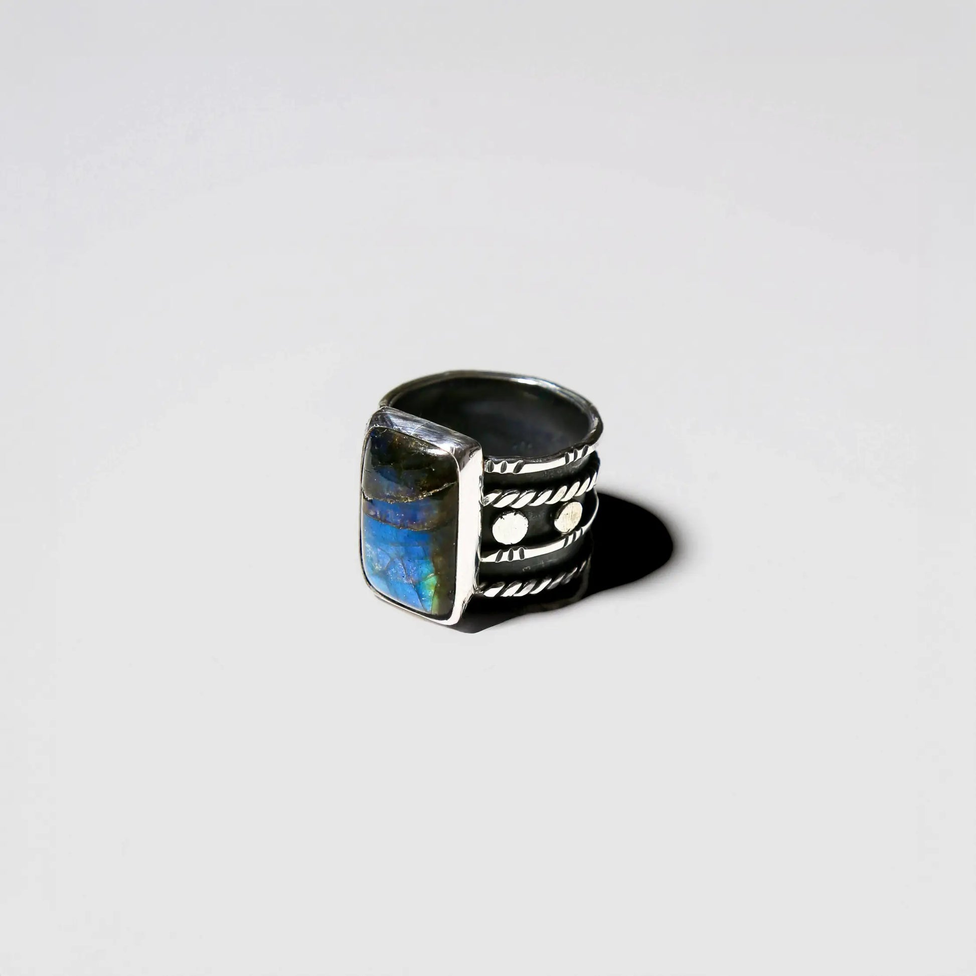Silver ring with blue stone on a light gray background