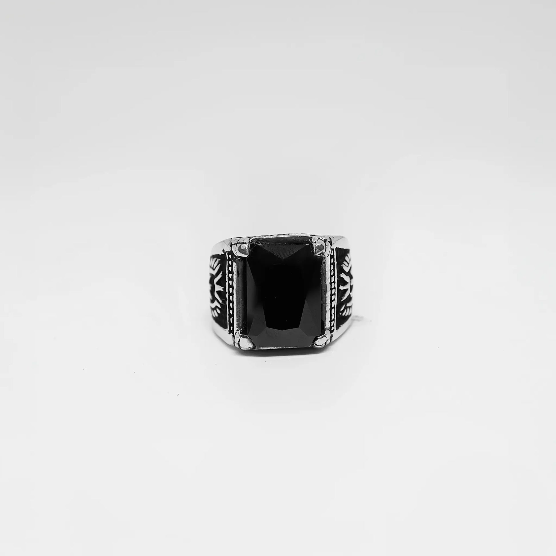 Silver ring with a black stone on a white background
