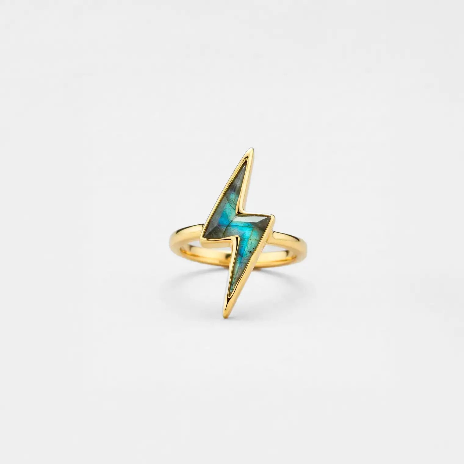 Gold lightning bolt ring with labradorite gemstone on a light gray background