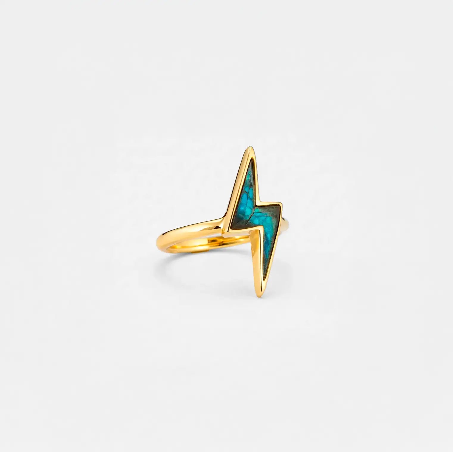 Gold lightning bolt ring with labradorite gemstone on a light gray background
