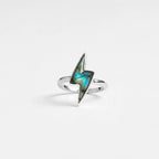 silver lightning bolt ring with labradorite gemstone on a light gray background