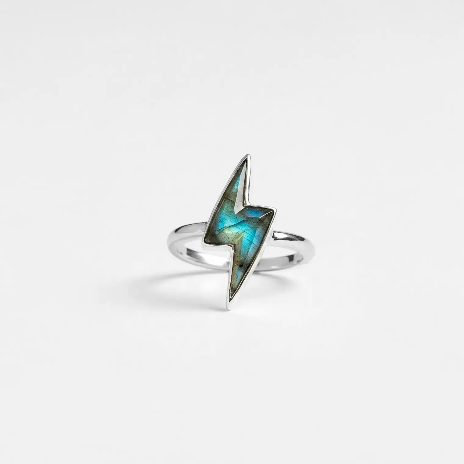 silver lightning bolt ring with labradorite gemstone on a light gray background
