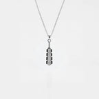 Necklace with a macahuitl pendant on a light gray background, aztec sword pendant