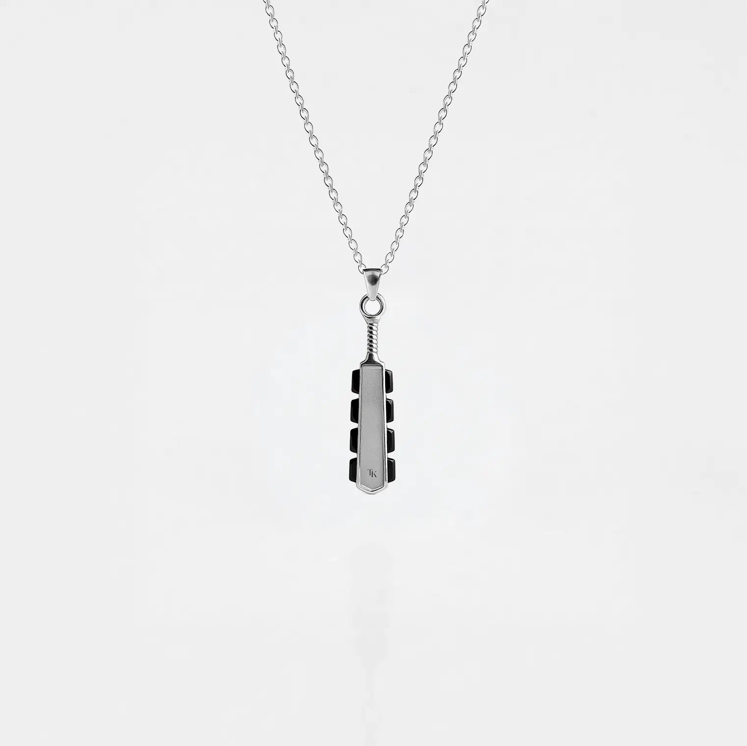 Necklace with a macahuitl pendant on a light gray background, aztec sword pendant