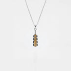 Necklace with a macahuitl pendant on a light gray background, aztec sword pendant