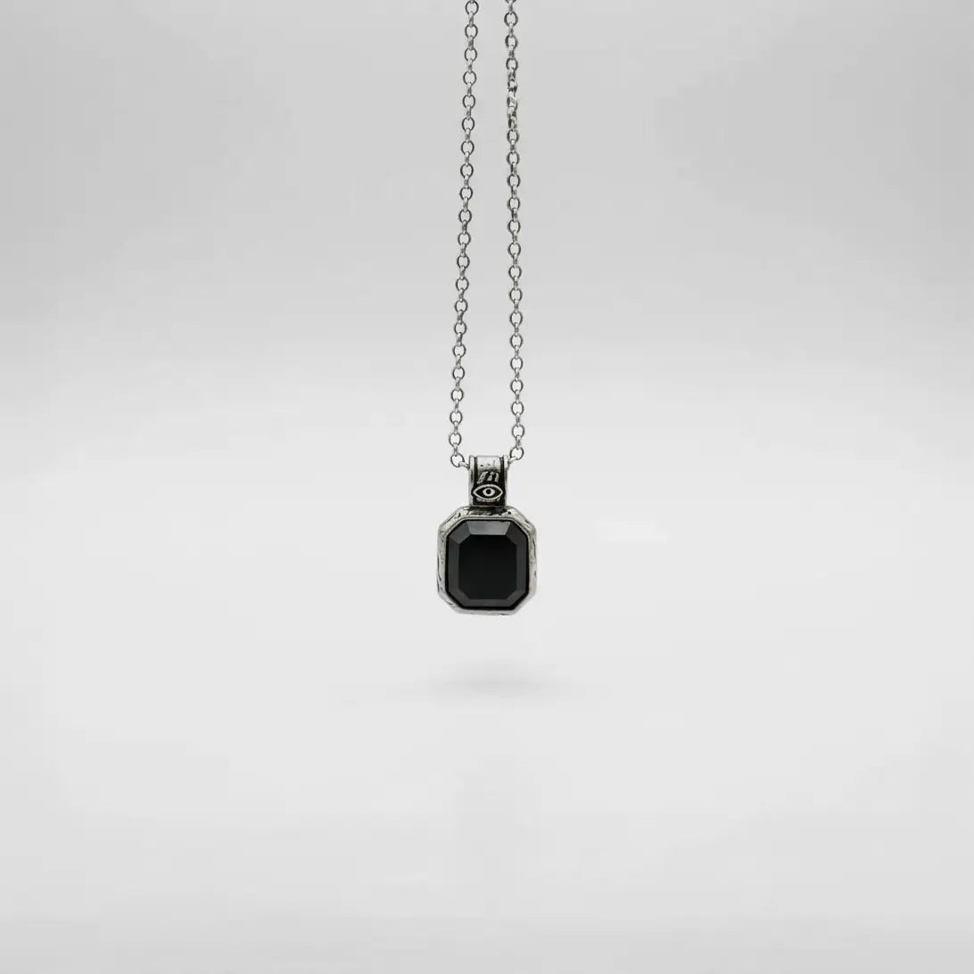 Silver necklace with a black pendant on a white background