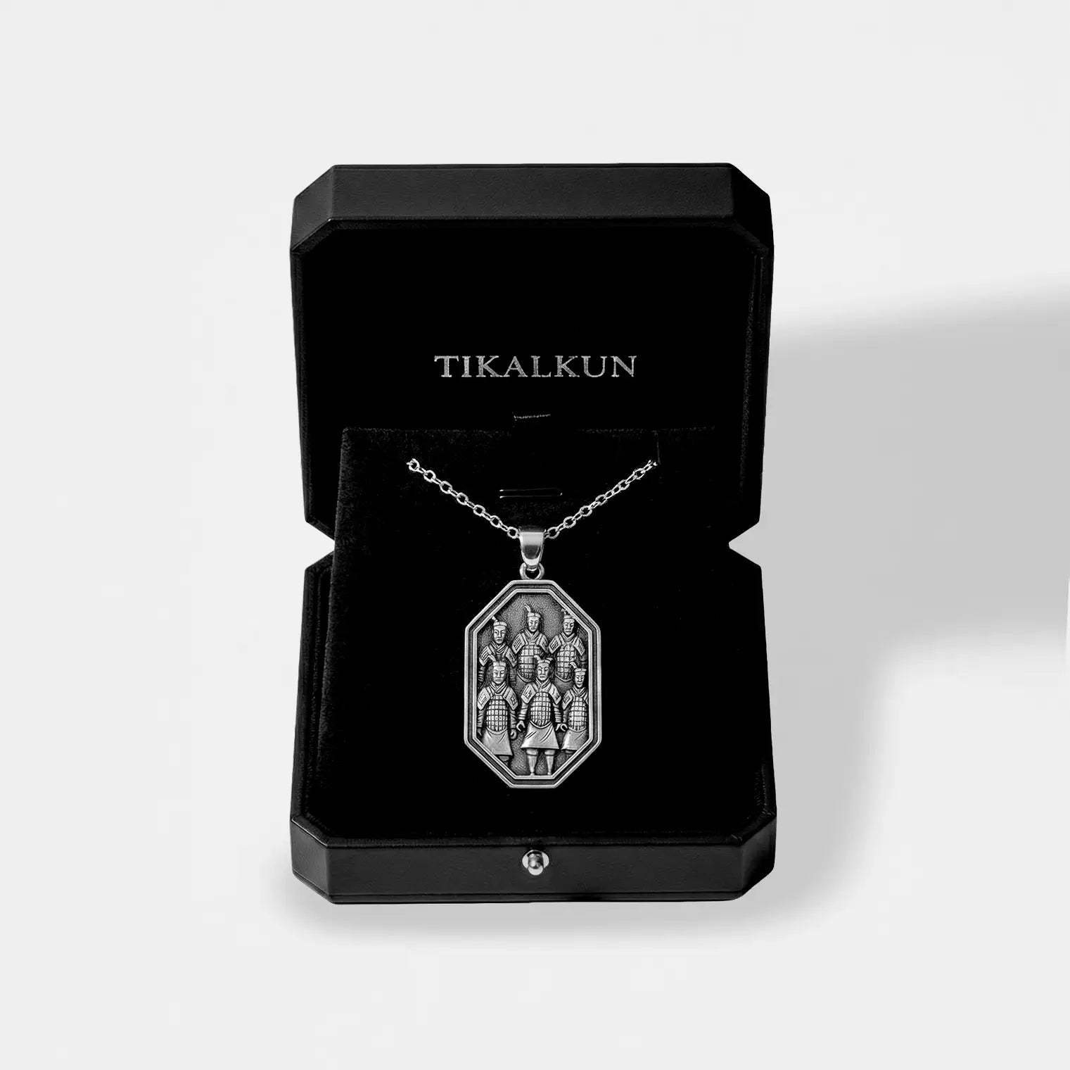 Silver necklace with a terracota's army pendant on a black Tikalkun display box.